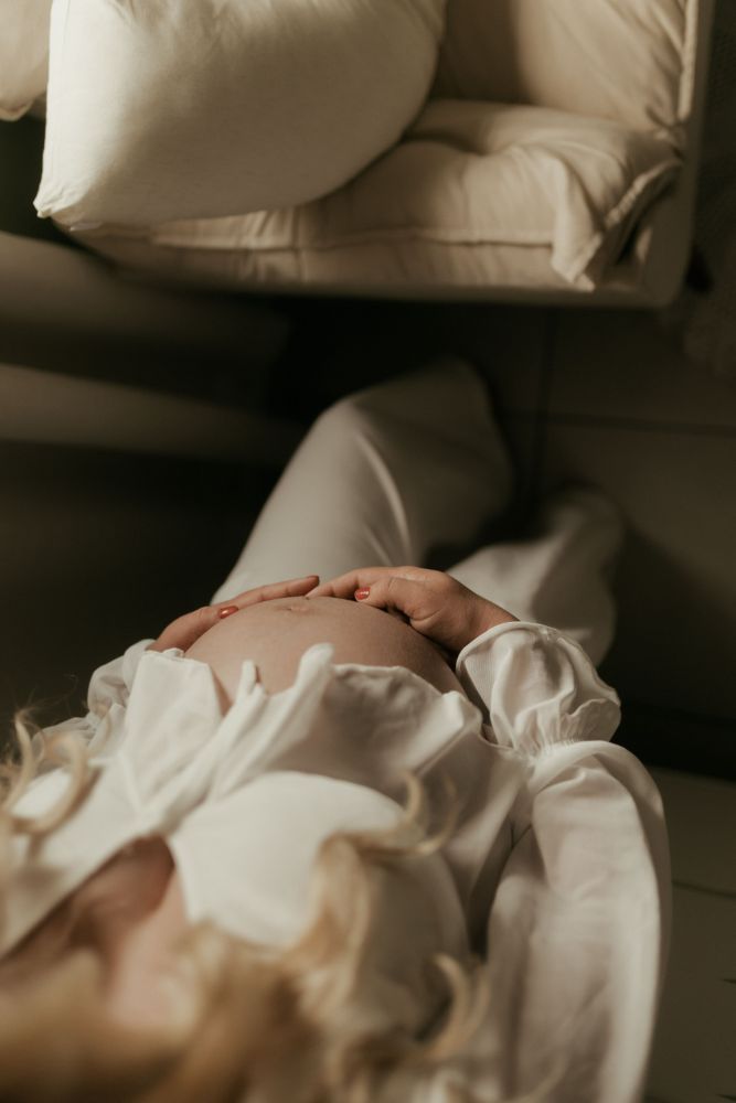 Une future mère allongée, la main posée sur son ventre