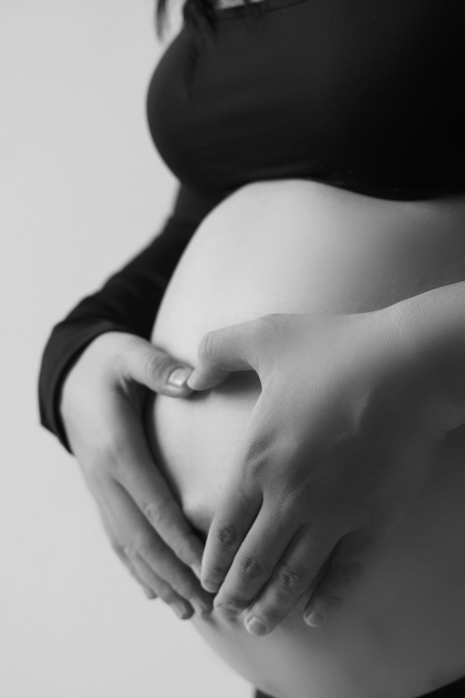 Une femme enceinte au coucher du soleil, le visage vers le ciel