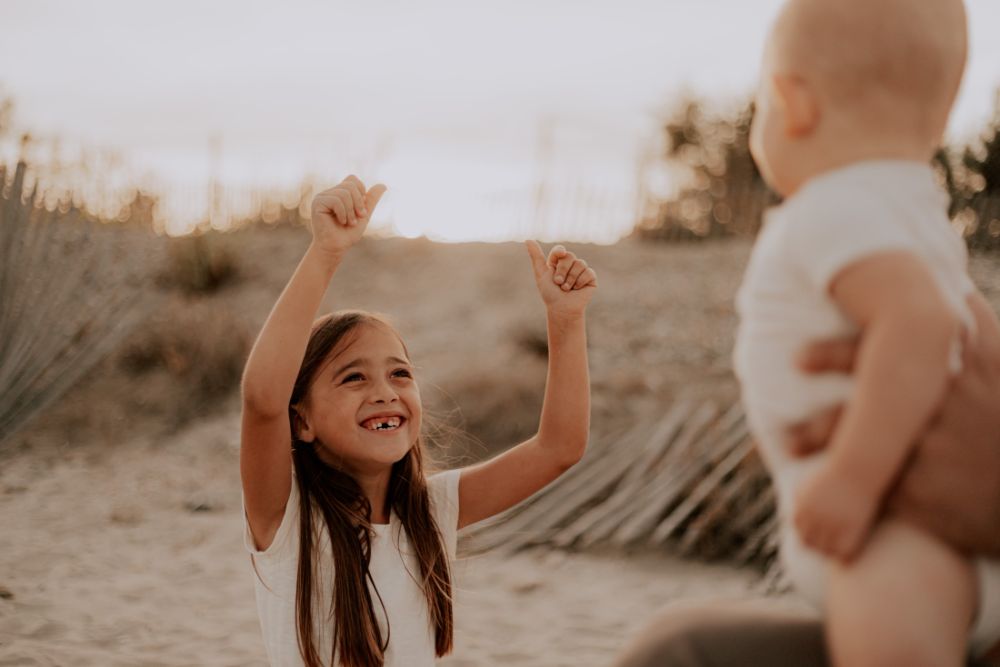 Une fillette lève les bras vers son petit frère