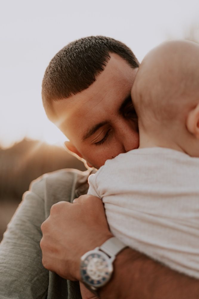 Un père serre son bébé contre son épaule