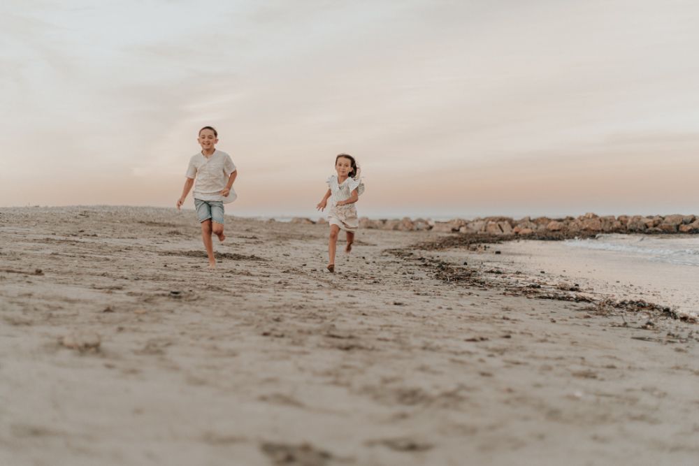 Deux enfants courant sur la plage au crépuscule