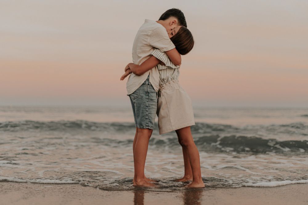 Frère et sœur enlacés dans les vagues