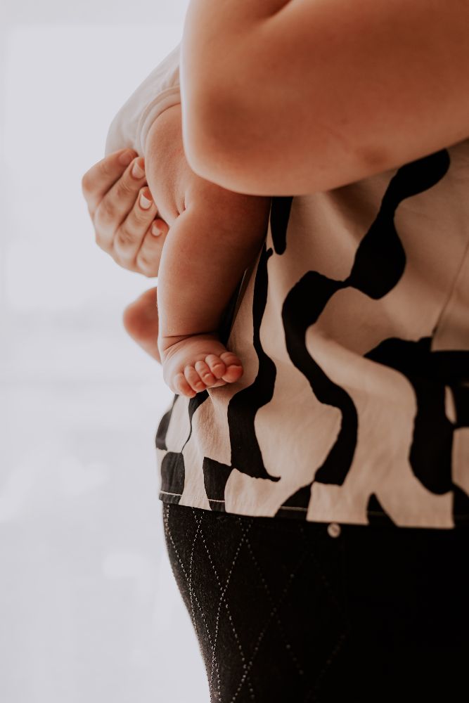Pieds d’un nouveau-né tenus par sa mère